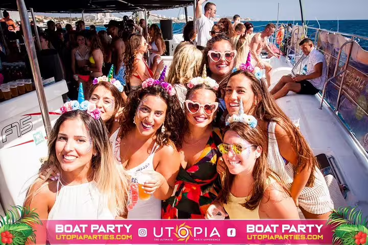 Group of friends enjoying Tenerife's all-inclusive mega boat party with drinks and festive attire under sunny skies.