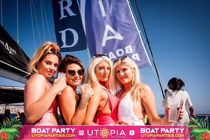 Group of friends enjoying Tenerife's all-inclusive mega boat party with drinks and sunshine.