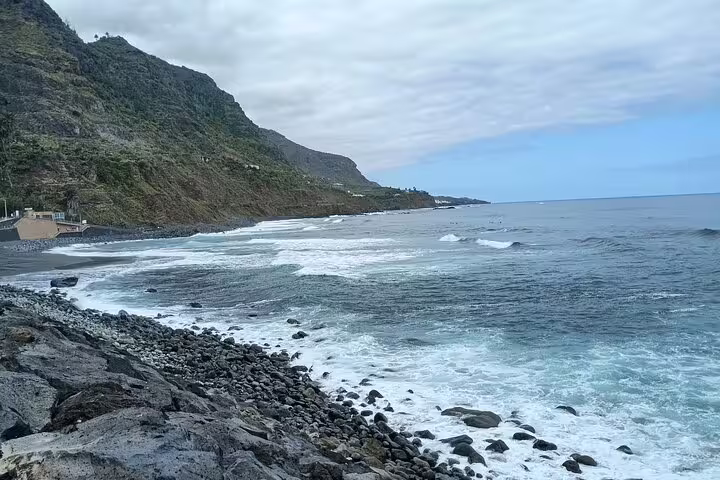 Scenic rocky beach with mountain backdrop on Tenerife's north coast, perfect for tranquil coastal walks.