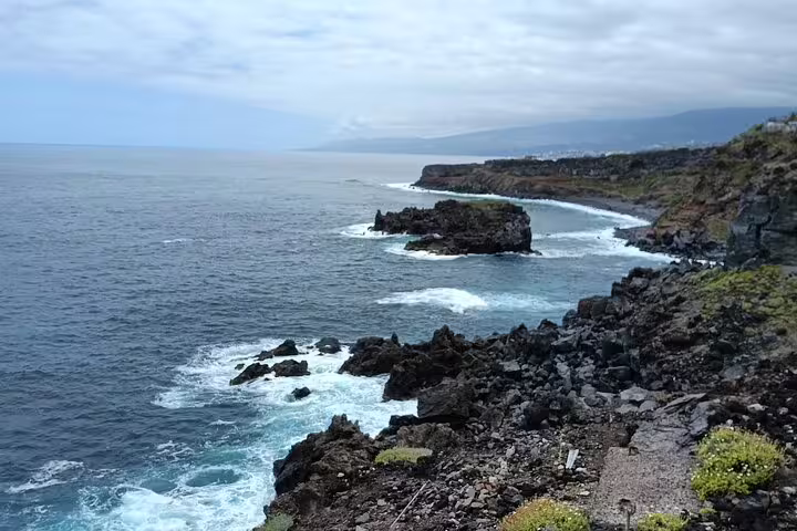 Dramatic rocky coastline with crashing waves, showcasing the natural beauty of Tenerife's north coast.