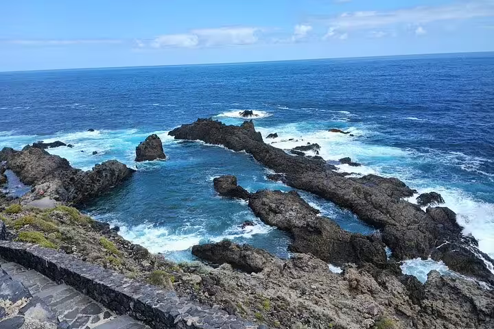 Dramatic rocky shoreline with clear blue waters on Tenerife's North Coast, featured in private 6-hour tours.