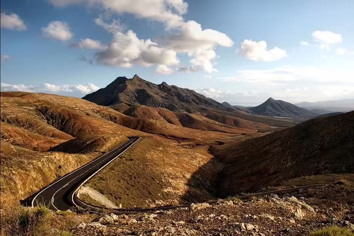 Dramatic mountain road winding through Tenerife's volcanic terrain, offering stunning views and adventurous driving routes.
