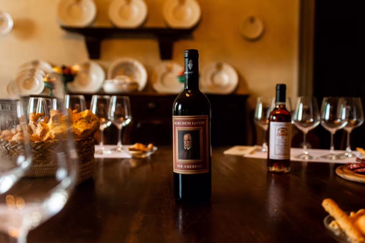 Tenuta Bossi wine tasting table with red wine bottle, glasses and Tuscan snacks for 3-wine experience