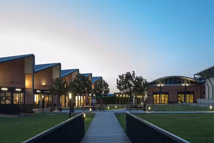 View of The Mall's modern architecture at dusk, showcasing high-end boutiques and serene walkways near Rome.