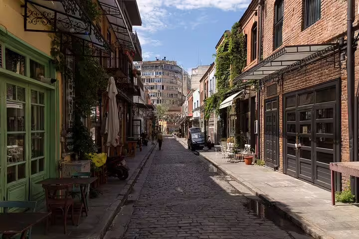 Charming street in Thessaloniki with cobblestones, vibrant cafes, and historic architecture, perfect for a custom sightseeing layover tour.