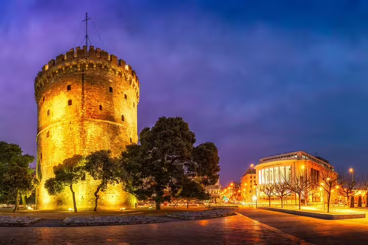 Illuminated White Tower and vibrant cityscape on a Thessaloniki by Night Private Custom Tour with a local guide.