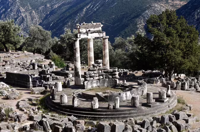 Tholos of Athena Pronaia ruins in Delphi with mountain views, key site on a private tour from Athens