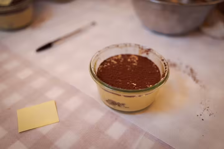 Close-up of freshly made tiramisu in a glass dish during a cooking class at Piazza Navona, Rome.
