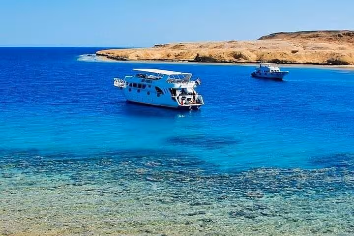 Boat cruising the crystal-clear Red Sea near Tiran Island, Sharm El Sheikh snorkeling tour with lunch