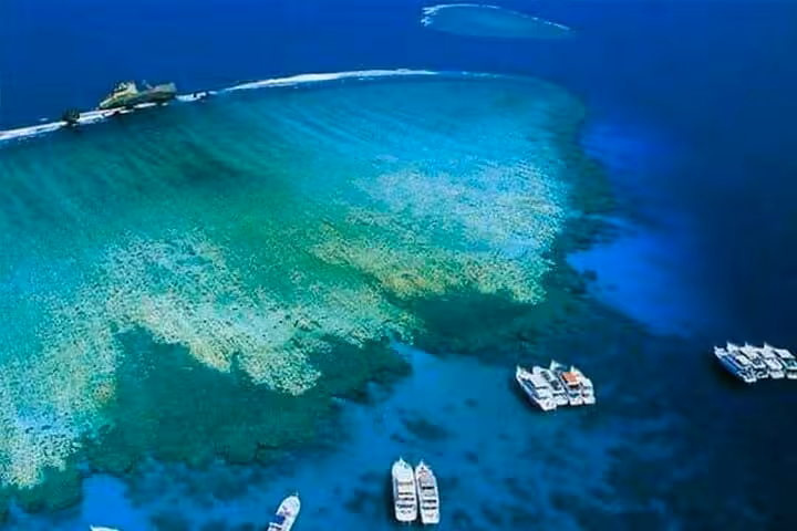 Aerial view of Tiran Island reef with tour boats in Sharm El Sheikh, Red Sea snorkeling day trip