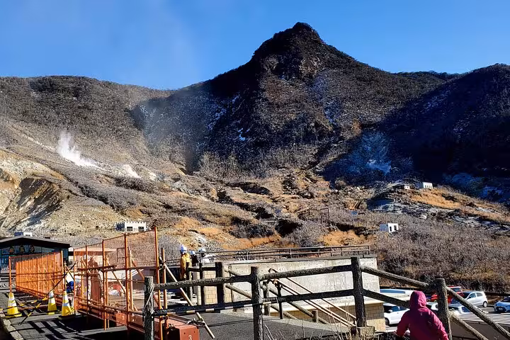 Tourists explore the rugged landscape of Owakudani with volcanic steam rising, part of a Hakone guided tour.