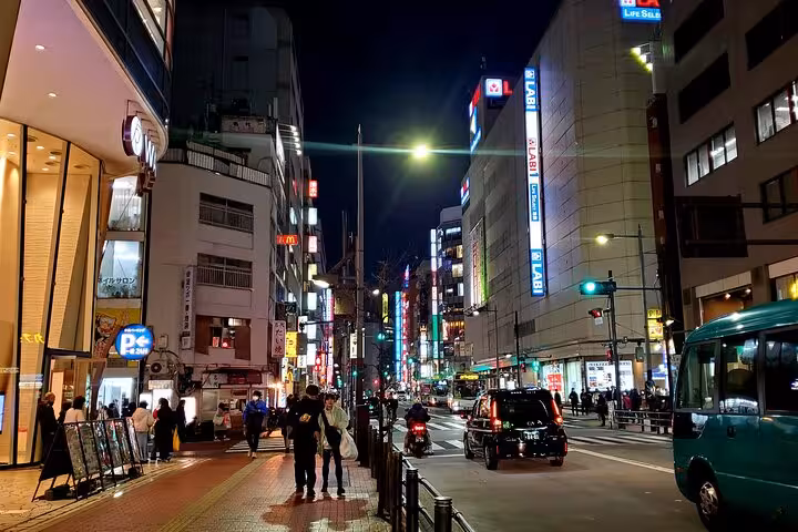 Tokyo night scene with brightly lit buildings and busy streets, perfect for a private guided city tour experience.