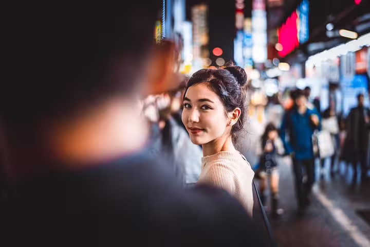 Candid Tokyo night street photo of woman looking back, ideal for personal vacation photographer tour session