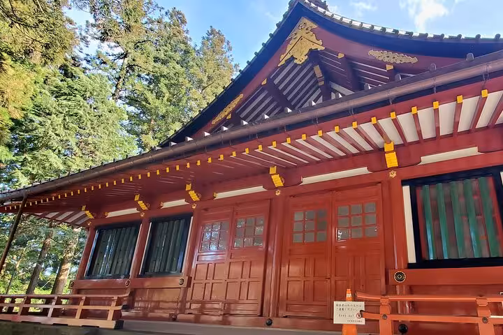 Beautiful red shrine building amidst forest scenery in Nikko, captured on the Tokyo to Nikko guided private tour.