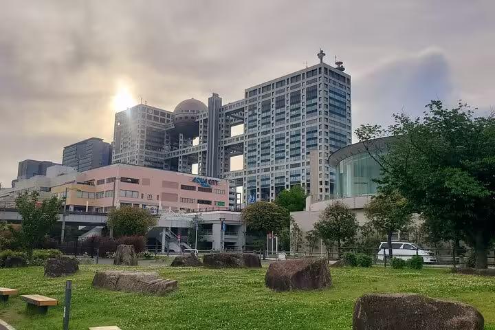 Sunset over Odaiba's futuristic architecture, highlighting Fuji TV building, ideal for a Tokyo private tour adventure.