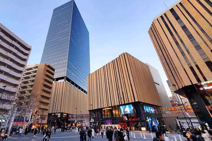 Bustling Tokyo shopping district with modern architecture and vibrant city life, perfect for a customized tour experience.