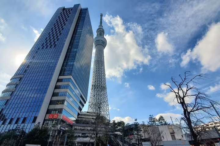 Tokyo Skytree and adjacent modern building under a vibrant blue sky, featured on a guided Tokyo and Mt. Fuji tour.