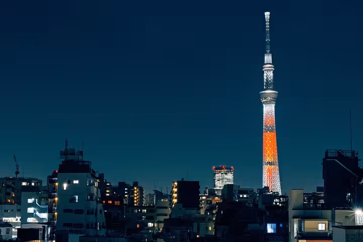 Tokyo Skytree illuminated at night, towering over cityscape on a customizable private tour with English guide.