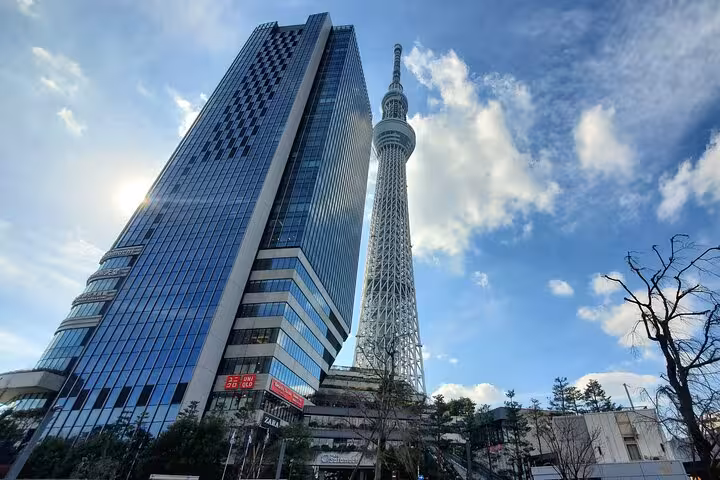Tokyo Skytree and adjacent skyscraper under a bright blue sky on a customizable private tour with English guide.