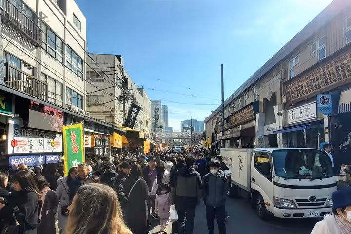 Bustling street market in Tokyo with crowds exploring local shops, part of the guided Tokyo and Hakone private tour.