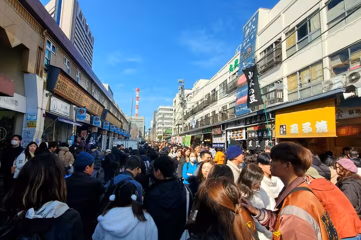 Crowded street scene at Tokyo's famous Tsukiji Outer Market during a customizable private tour.