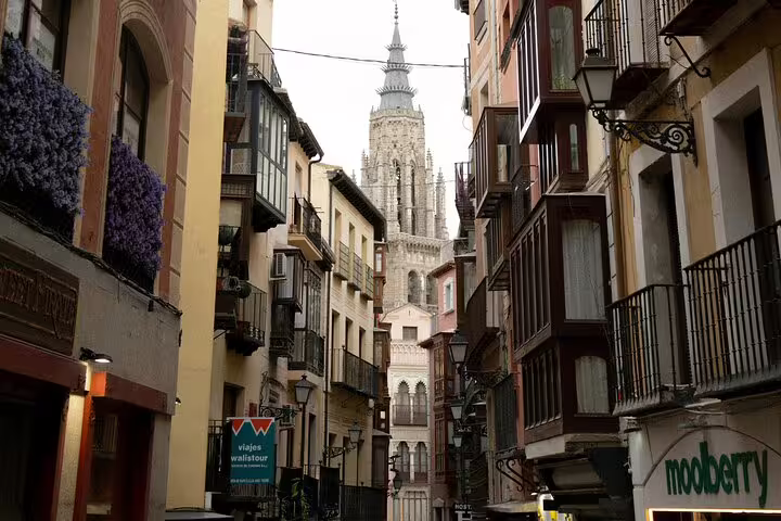 Narrow Toledo old town street with cathedral tower view, ideal stop on private half-day Toledo tour by minivan