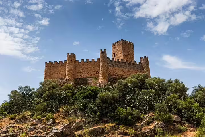 Majestic view of the historic Tomar Castle under a blue sky, featured in our customizable private day trip from Lisbon.