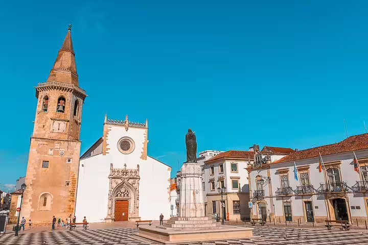 Explore historic architecture and vibrant culture in Tomar's town square on a private full-day tour from Lisbon to Tomar and Coimbra.