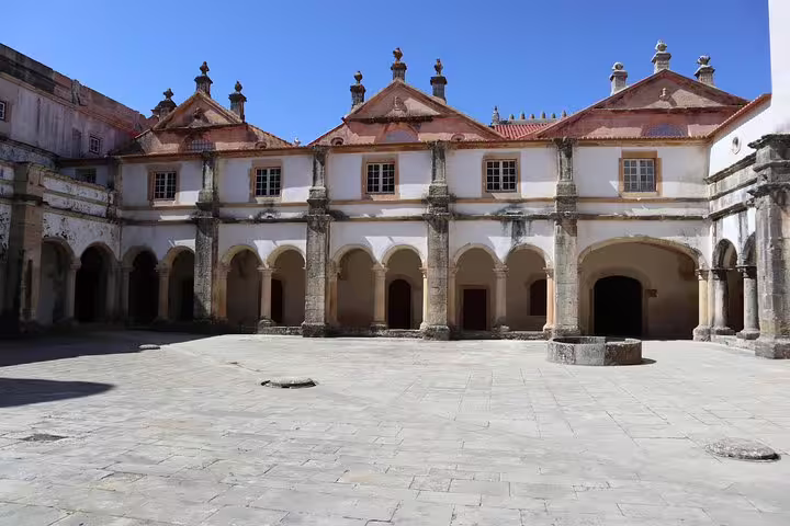 The cloisters of the Convent of Christ in Tomar, showcasing intricate arches and historic architecture.