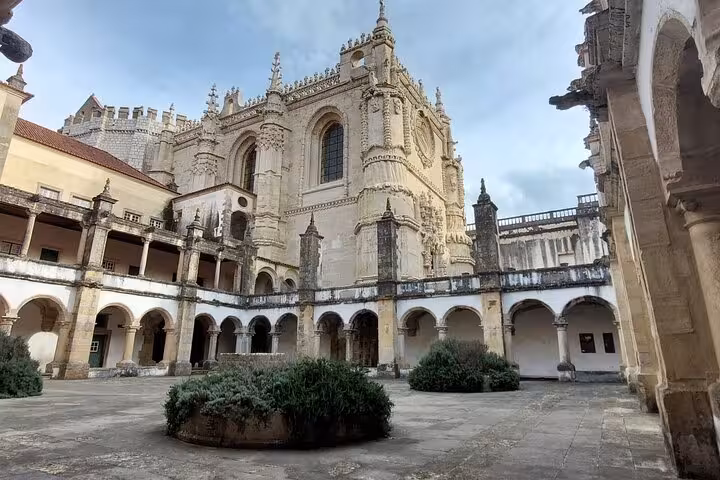 The grand Gothic architecture of the Convent of Christ's courtyard, a key attraction on the Tomar walking tour.