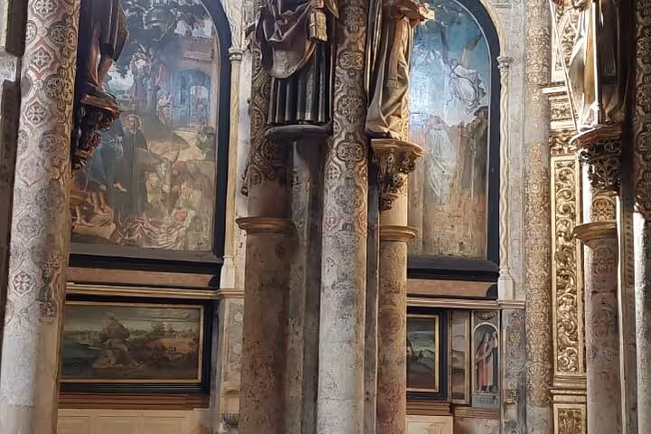 Interior view of the Convent of Christ with ornate columns and historic frescoes, highlighting Tomar's rich heritage.
