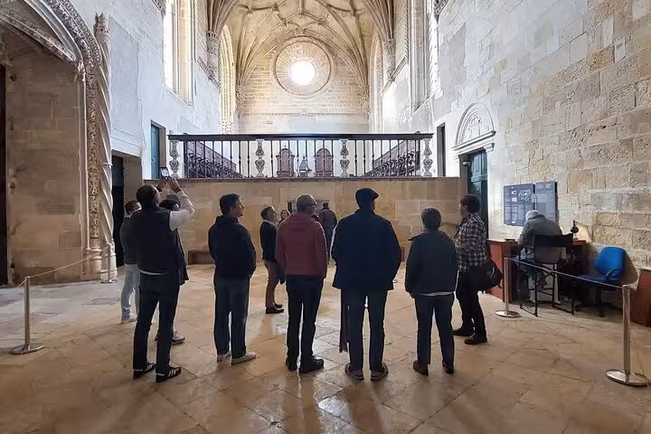Visitors inside the Convent of Christ admiring the intricate architecture on a guided Tomar tour.