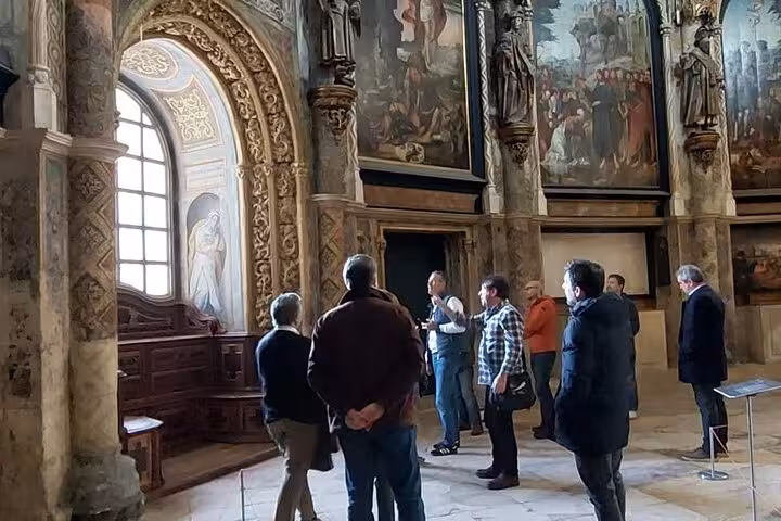Visitors explore the historic Convent of Christ gardens on a sunny day during a private walking tour in Tomar, Portugal.