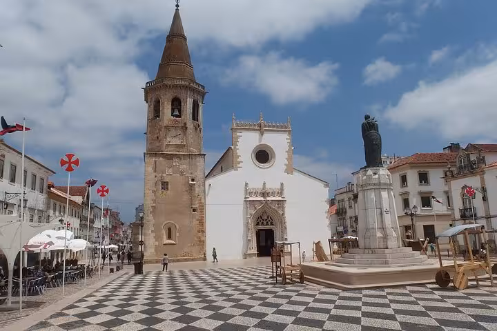 Tomar's scenic main square with iconic church and statue, perfect for immersive historical walking tours in Portugal.