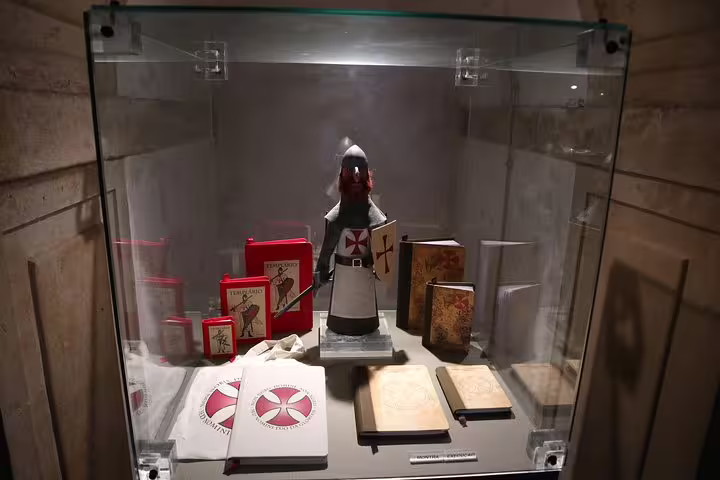 Templar-themed souvenirs in a glass case, featured on the Tomar and Mafra Small Group Tour from Lisbon.