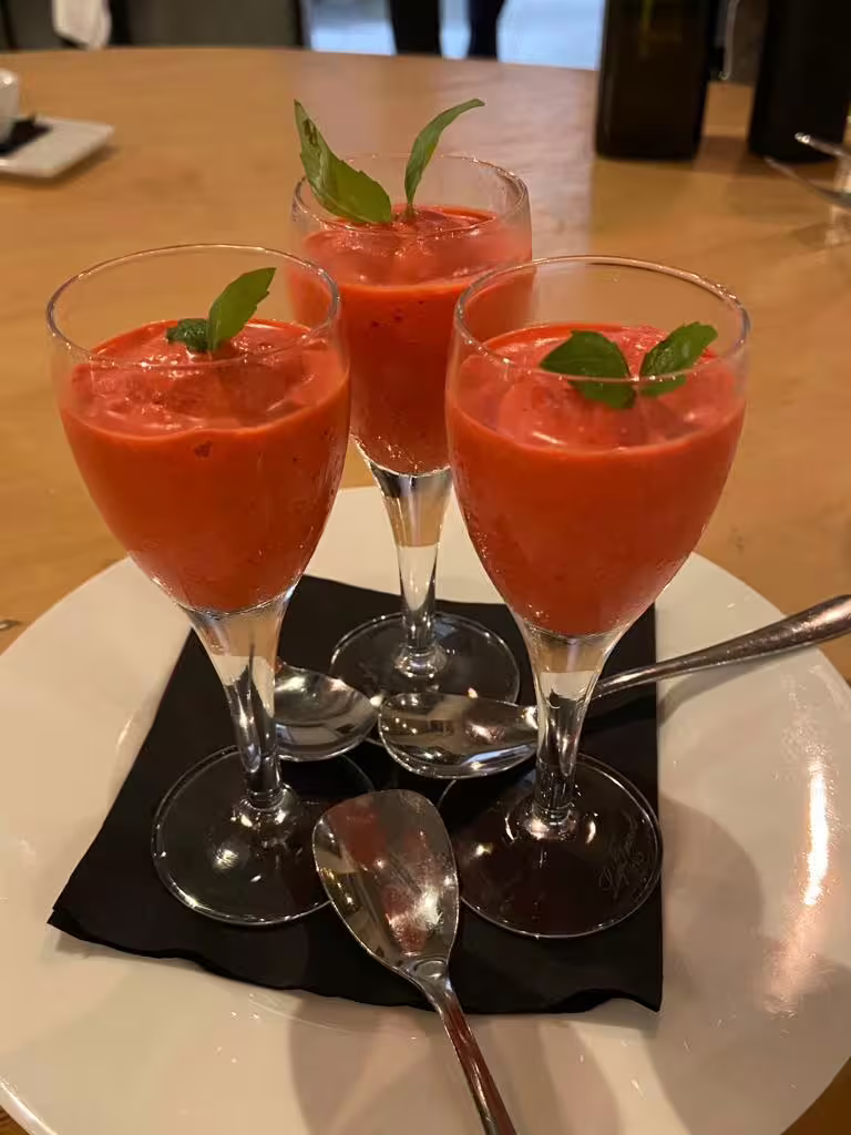 Three tomato gazpacho aperitif shots garnished with basil, served at chef Angelo Lanaro’s home restaurant
