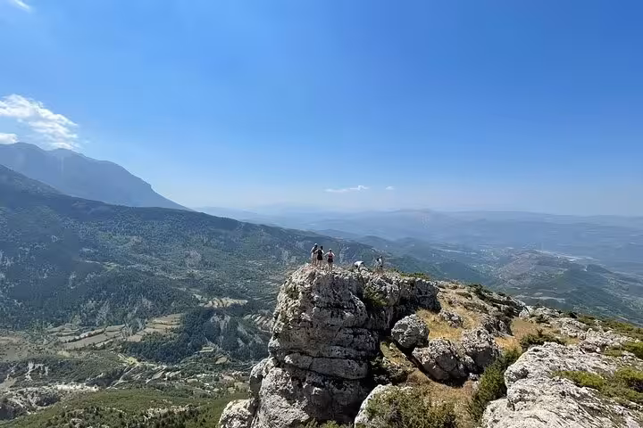 Hikers standing on a rocky peak with panoramic views during the Tomor Mountain Lakes of Dardhe Hiking Tour.