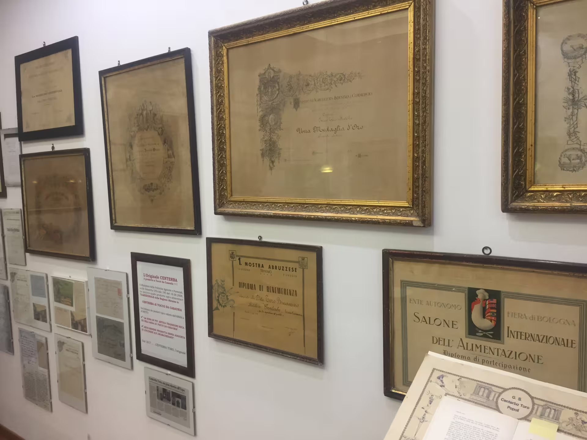 Parete con certificati storici nella distilleria Toro durante visita guidata e degustazione di liquori artigianali