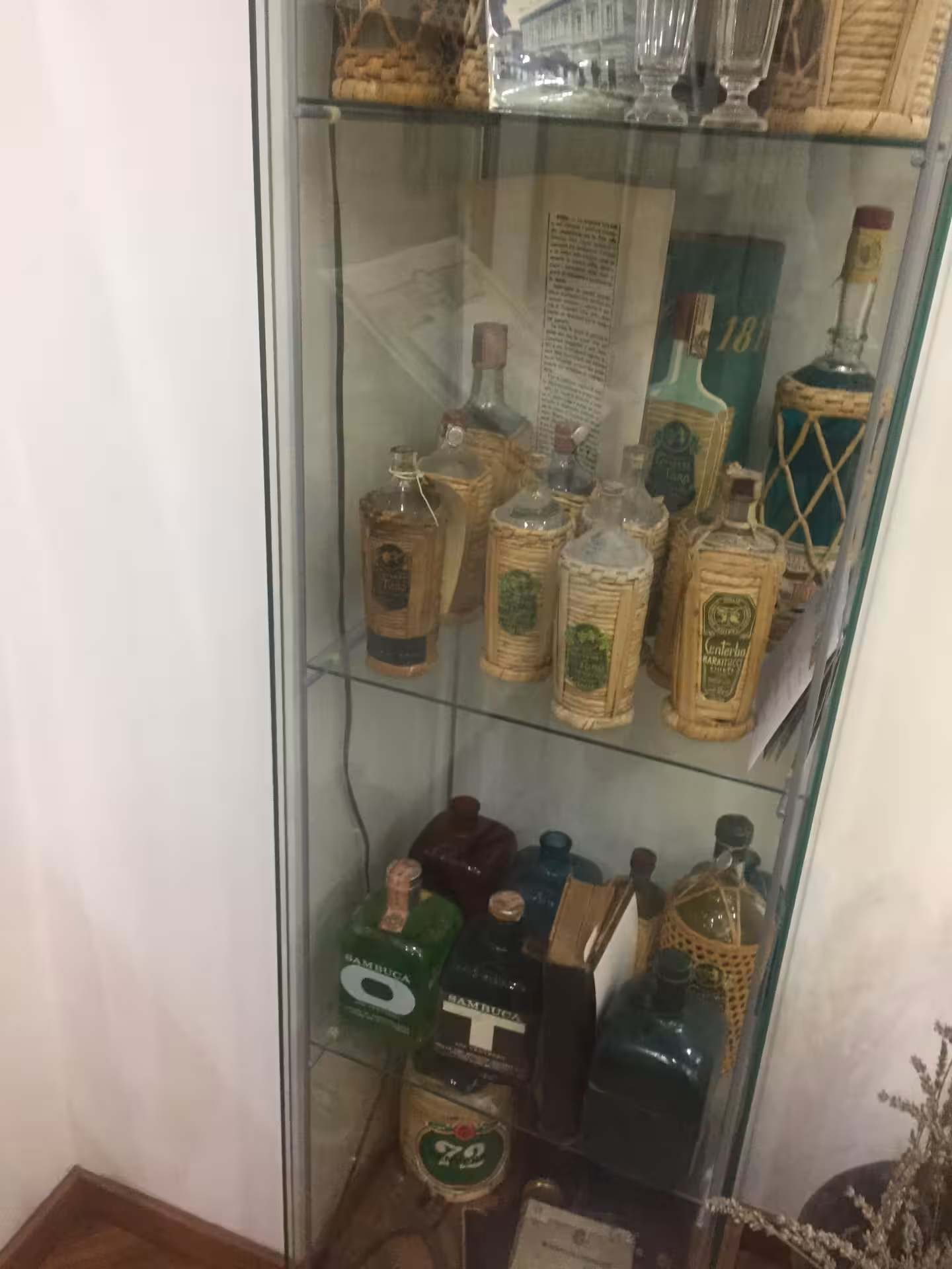 Vetrina con liquori Toro e bottiglie d’epoca, tappa della visita guidata e degustazione in distilleria