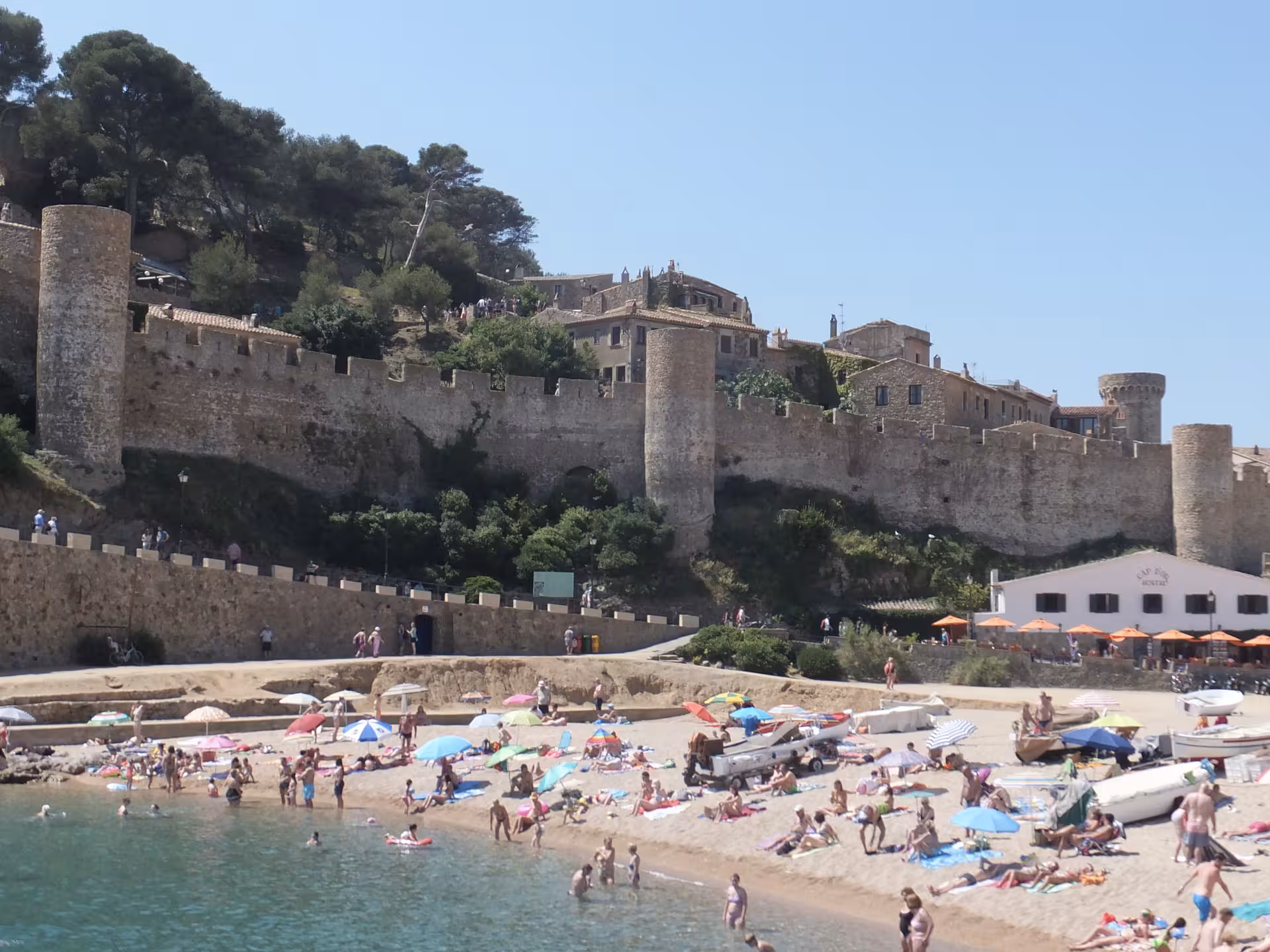 Tossa de Mar beach and medieval walls on Costa Brava, popular day trip from Barcelona for swimming