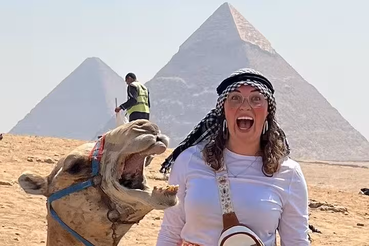 Tourist with camel at Giza Plateau with pyramids backdrop on Grand Egyptian Museum and Giza Pyramids tour with lunch