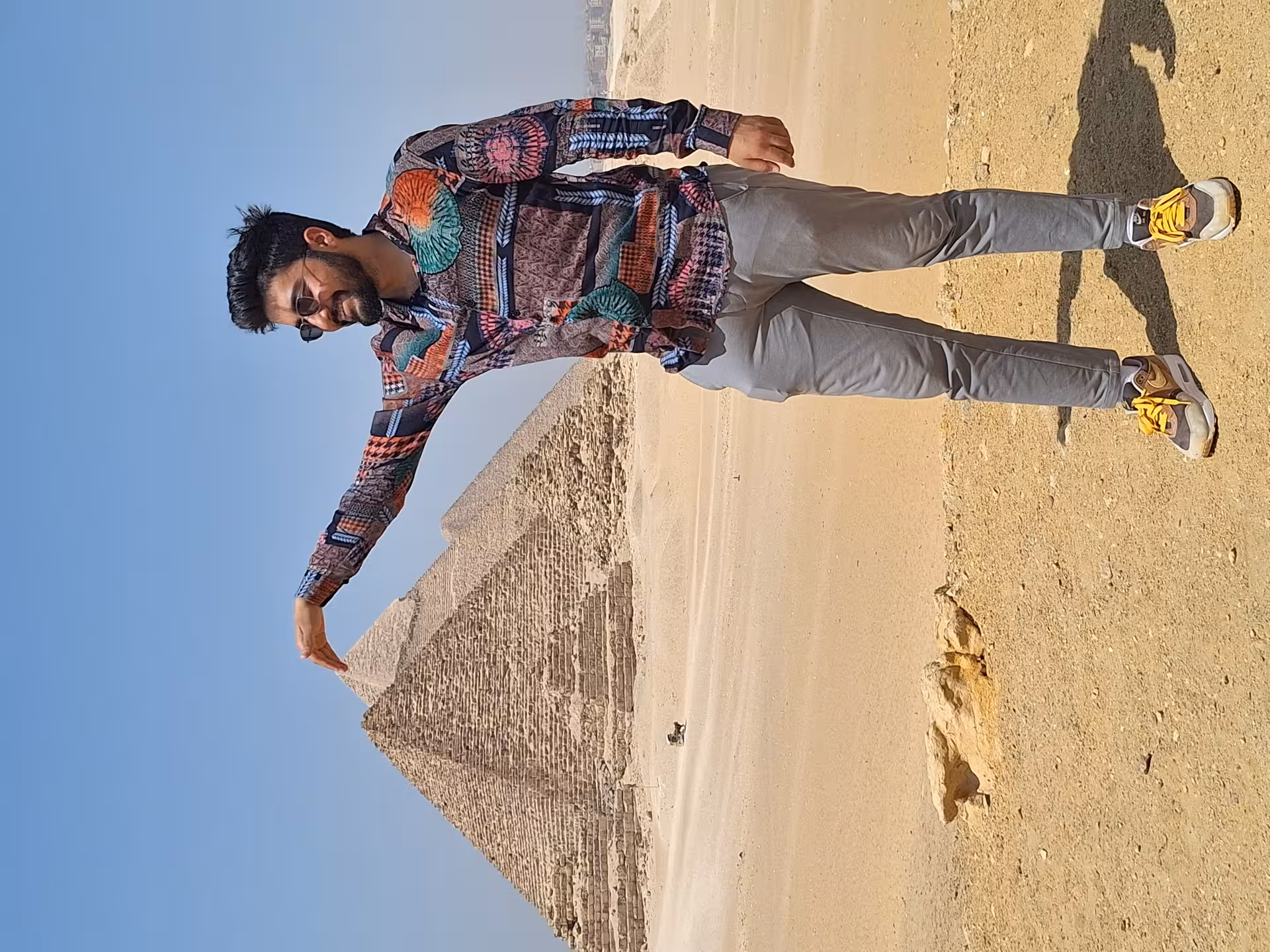 Tourist playfully posing with the Great Pyramid of Giza, capturing the iconic desert landscape in Cairo, Egypt.