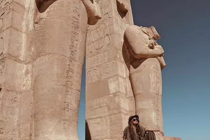 Tourist by colossal Ramses II statue at Luxor Temple, East Bank Nile sightseeing on Luxor day tour