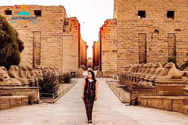 Tourist walking the sphinx avenue at Karnak Temple on Luxor East Bank tour, Egypt sightseeing