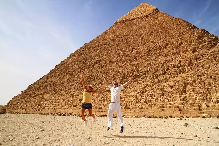 Tourists jumping by the Great Pyramid of Giza on a Cairo day tour to pyramids, Sphinx and Grand Egyptian Museum