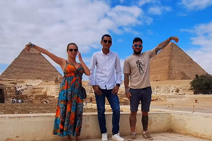 Tourists posing playfully in front of the Pyramids of Giza on a sunny day during a private Egyptian tour.