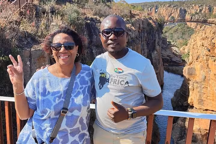 Happy tourists posing with scenic canyon views in the background during a memorable guided experience tour.
