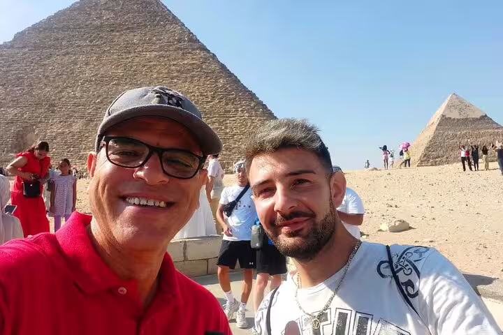 Tourists selfie at the Giza Pyramids near Cairo, popular layover tour stop before Memphis and Dahshur