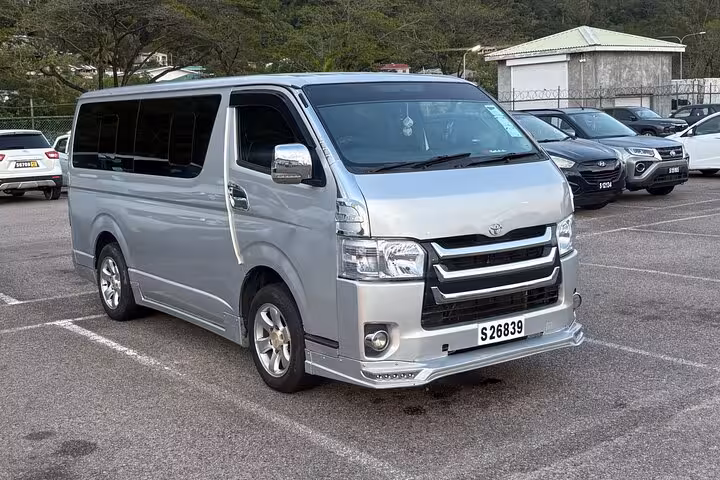 Silver Toyota minivan parked, ideal for comfortable private transfers in scenic Seychelles.