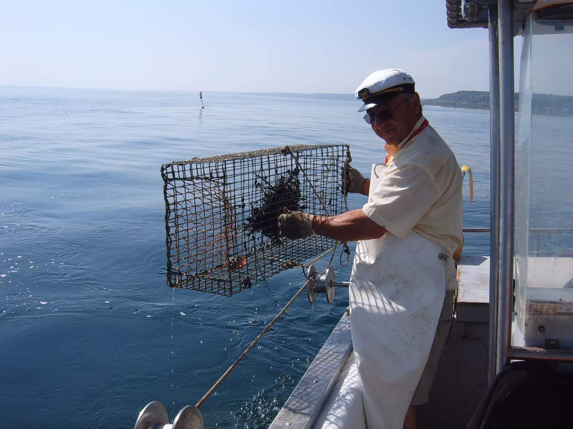 Fisherman lifting a lobster trap from the Adriatic during a Trabocchi Coast, Abruzzo fishing tourism boat tour